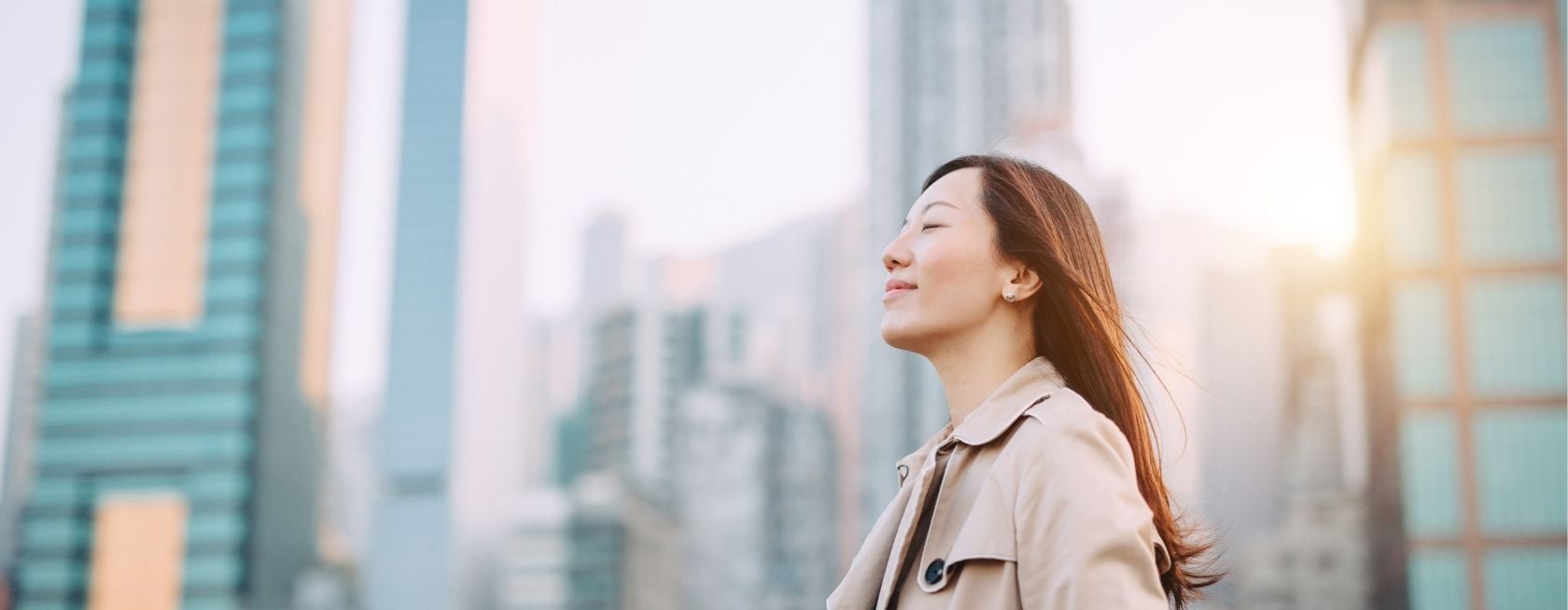 Woman taking a deep breath on city office roof terrace