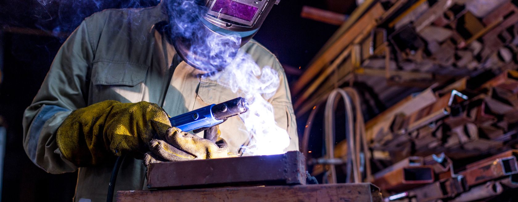 Industrial worker lat the factory welding steel