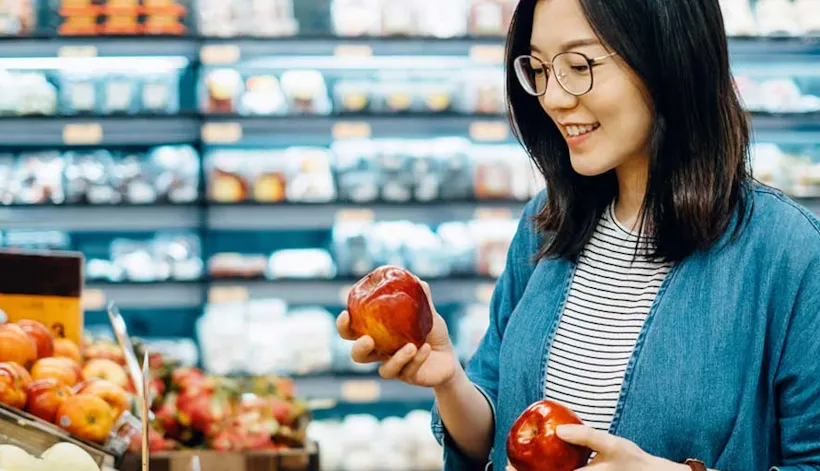 Woman picking apples in grocery store