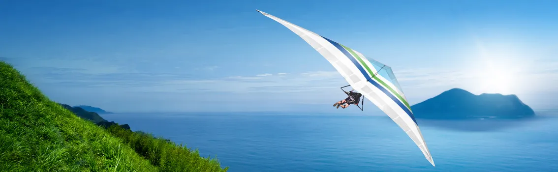 Man flying hangglider on the coast